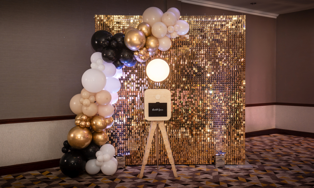 Photo booth with balloons and gold sequin wall set up